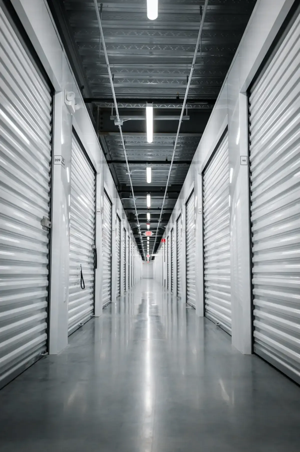 Bright interior hallway lined with rows of white storage units