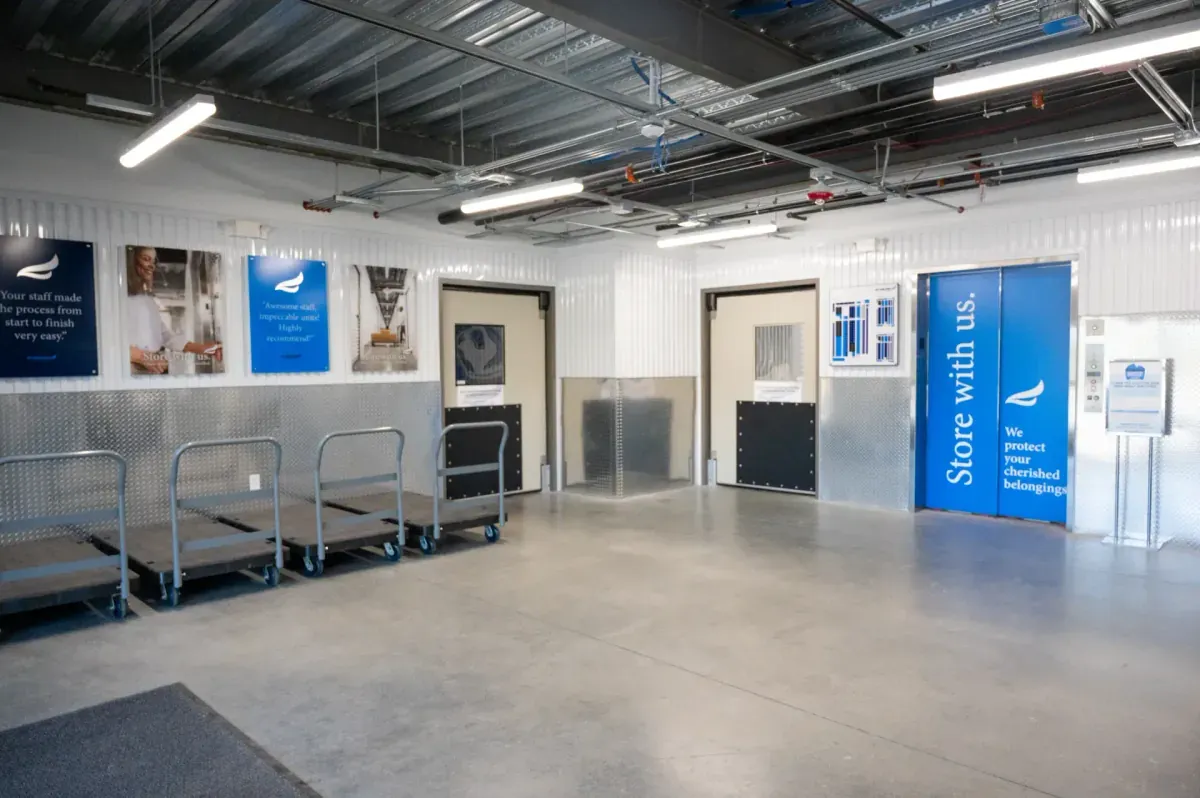 Bluebird Self Storage loading area with moving carts, elevator, and branded signage