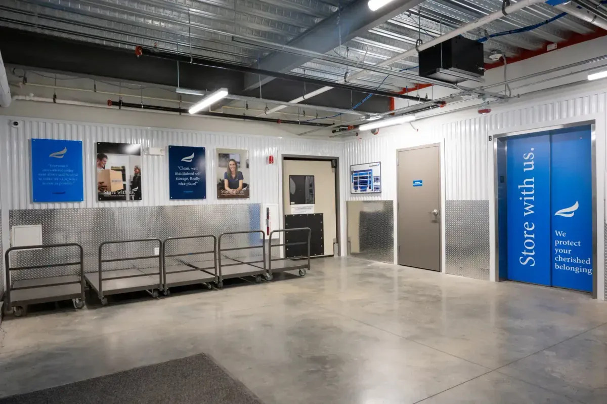 Indoor loading area with carts and branded elevator