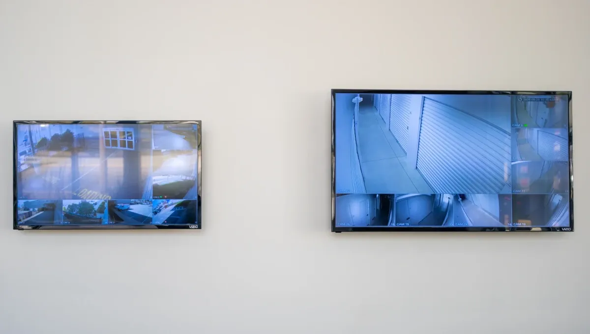 Two security camera monitors on office wall