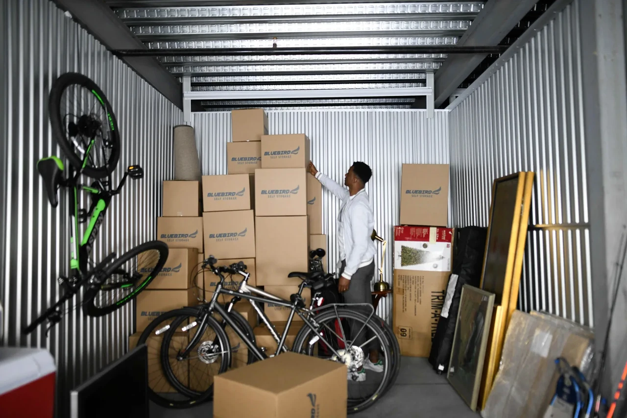 A man checking his brown storage boxes in a unit.