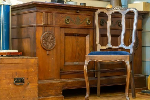 A vintage wooden chest next to a wooden chair