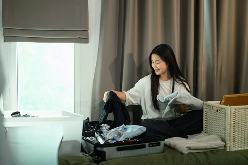 A female student packing her suitcase up in her dorm at the end of the semester.