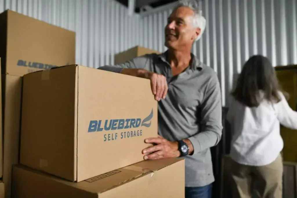 Man and woman with boxes in climate controlled storage unit.